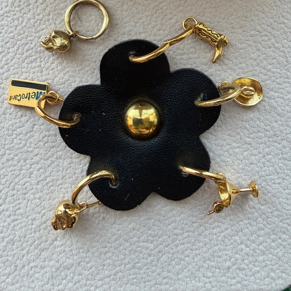 Gold plated Huggies metro card, cowboy boot, skull, cowboy hat and martini